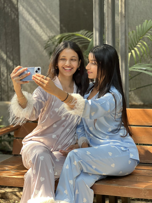 2 girls wearing Velure satin night suits taking a selfie and having fun