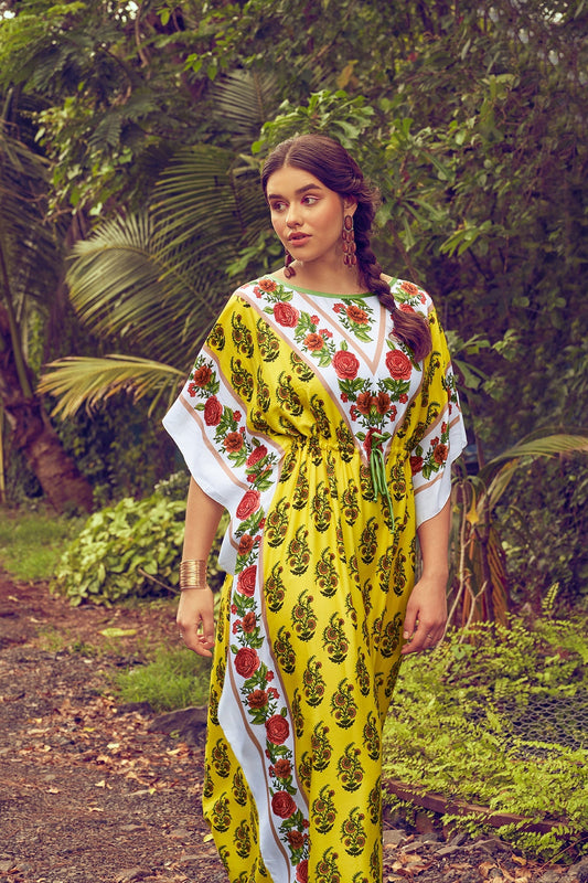 Woman wearing a yellow kaftan with jaipuri prints and a tie up in the centre in a forest background