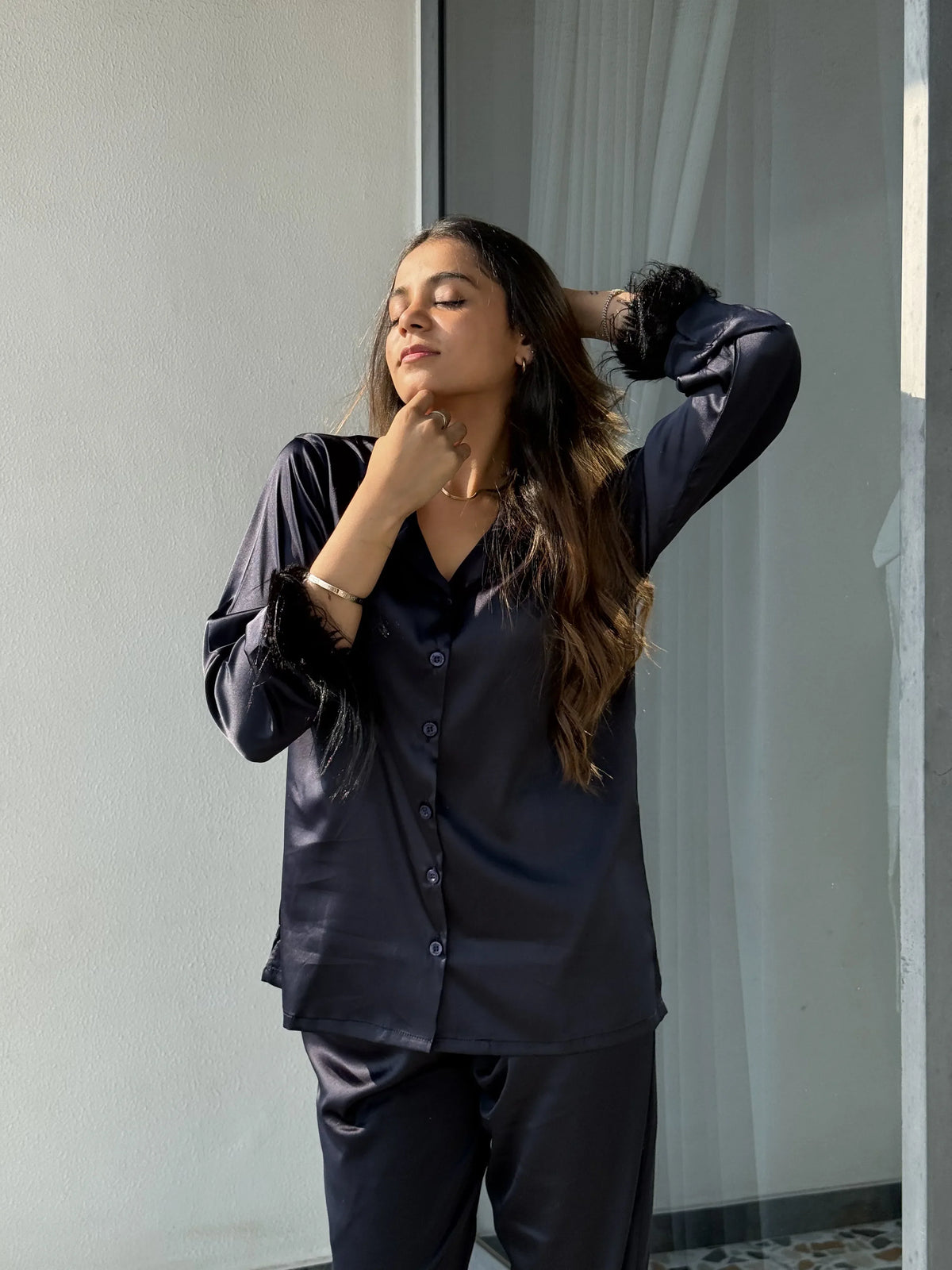 woman wearing black satin fur night suit from Velure in a balcony