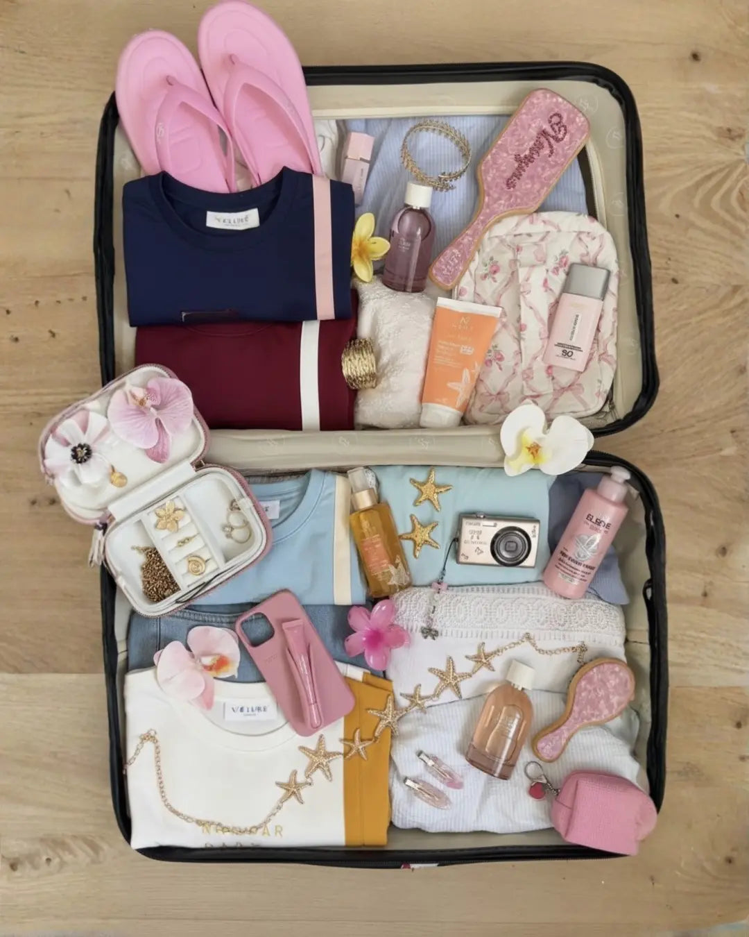 a suitcase filled with travel essentials and 4 velure scuba cotton travel sets.