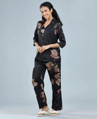 Velure Glossy Black Floral Print Satin Night Suit - Velure, Long Top and Pant, Elevate your weekend wardrobe with Velure's Glossy Black Floral Satin Print Night Suit. Crafted from silky smooth satin, this set guarantees unmatched comfort and softness. The vibrant floral print adds a touch of joy to the ensemble. Featuring a 3/4 sleeve shirt and full-length pants with an elastic waistband, this suit ensures a snug and cozy fit. Indulge in a peaceful sleep accompanied by pleasant dreams.