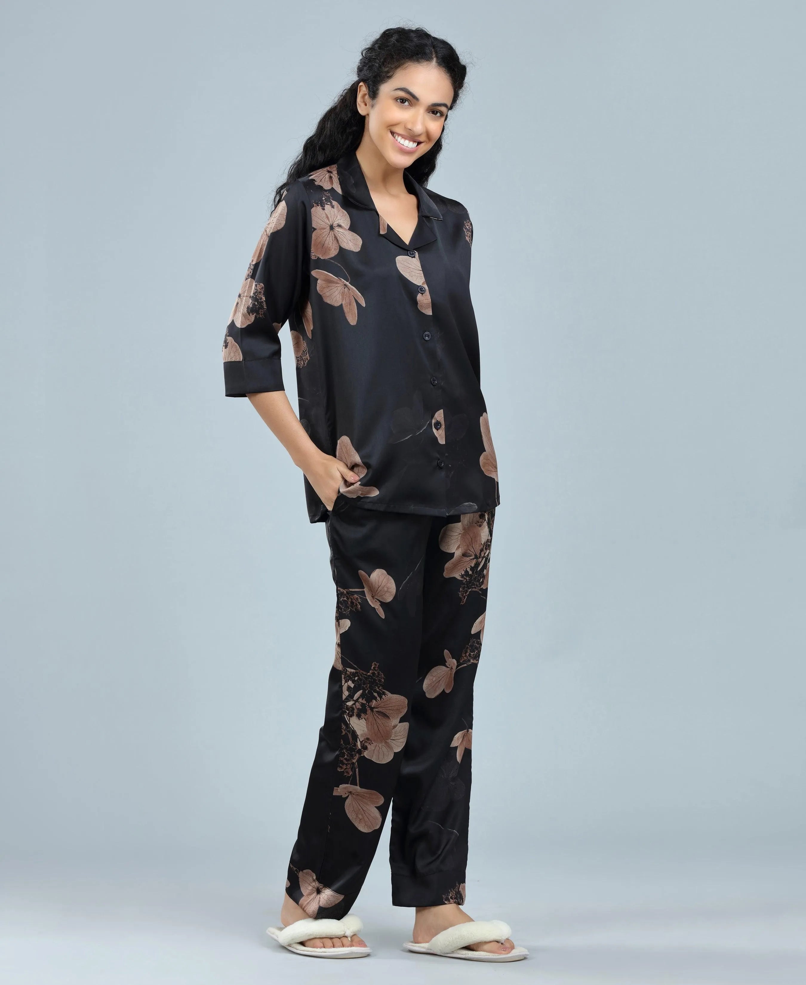 Velure Glossy Black Floral Print Satin Night Suit - Velure, Long Top and Pant, Elevate your weekend wardrobe with Velure's Glossy Black Floral Satin Print Night Suit. Crafted from silky smooth satin, this set guarantees unmatched comfort and softness. The vibrant floral print adds a touch of joy to the ensemble. Featuring a 3/4 sleeve shirt and full-length pants with an elastic waistband, this suit ensures a snug and cozy fit. Indulge in a peaceful sleep accompanied by pleasant dreams.